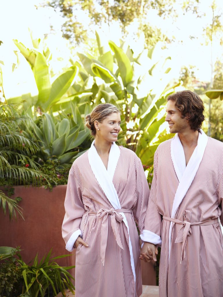 Caucasian couple in robes holding hands